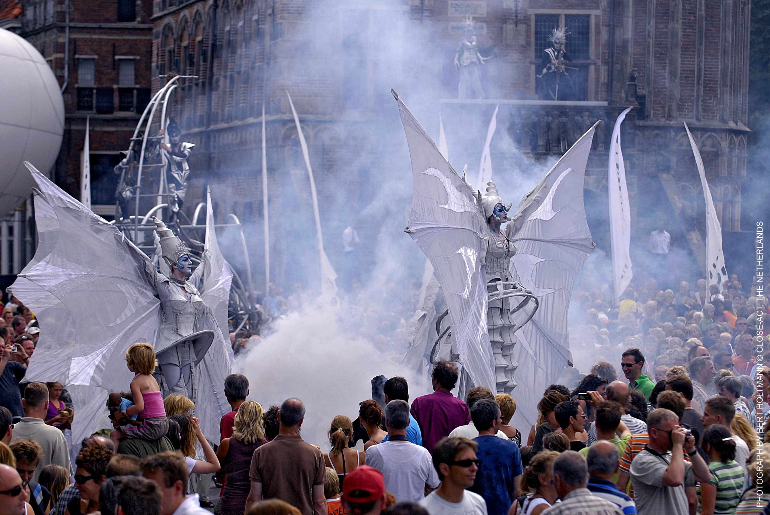 Close-Act Theatre makes street-theatre spectacles for festivals and events. With stilts, mobile objects and beautiful costumes we create an imaginary world for you to enjoy. Le théâtre Close-Act crée des spectacles de théâtre de rue pour les festivals et les événements. Avec des échasses, des objets mobiles et de beaux costumes, nous créons un monde imaginaire dont vous pourrez profiter. Close-Act Theatre hace espectáculos de teatro callejero para festivales y eventos. Con zancos, objetos móviles y hermosos trajes, creamos un mundo imaginario para que disfrutes.