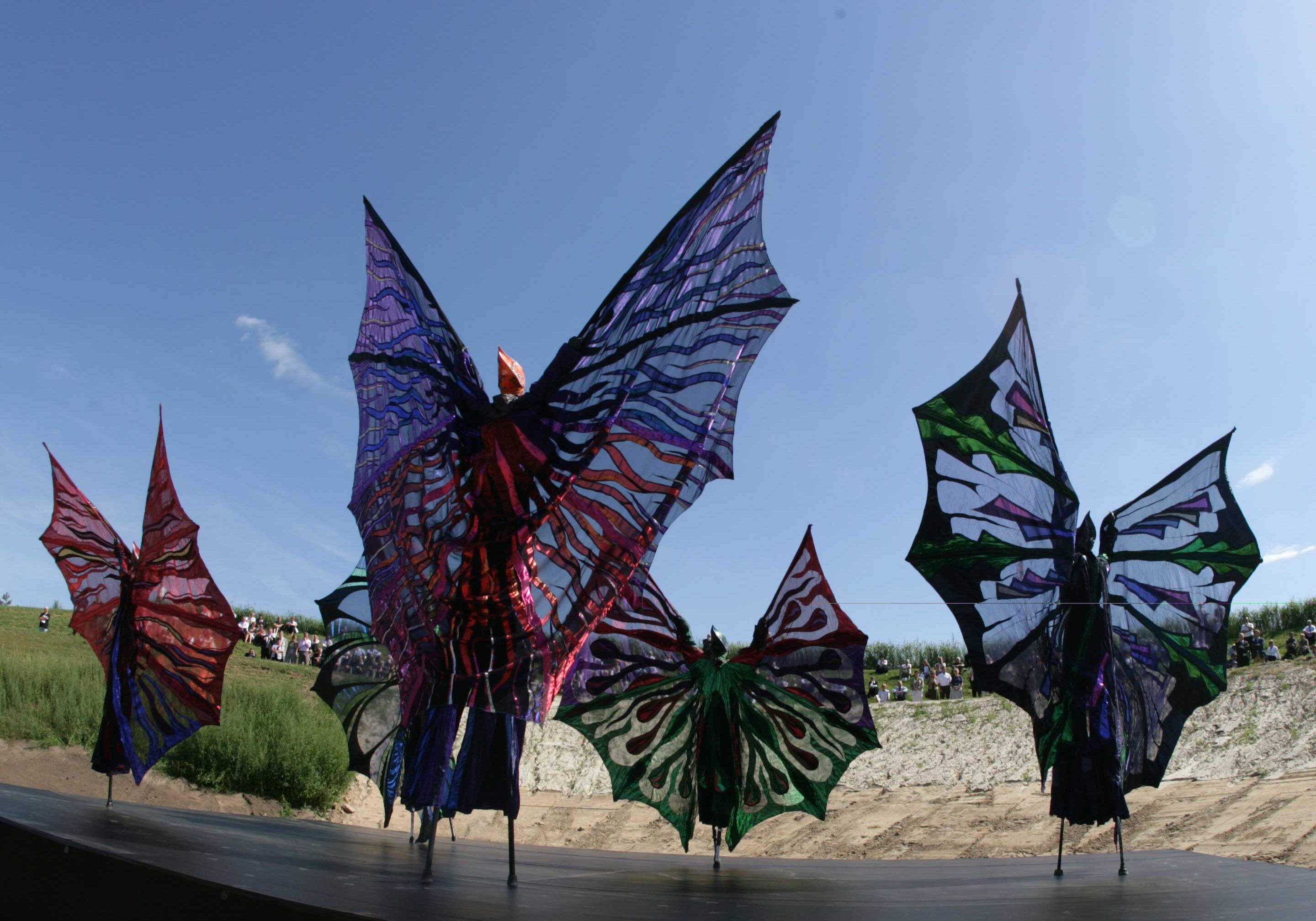 Close-Act-Theatre-production-mobile-act-Coloured-Wings-4-photo-by-Renier-Linders Close-Act Theatre makes street-theatre spectacles for festivals and events. With stilts, mobile objects and beautiful costumes we create an imaginary world for you to enjoy. Le théâtre Close-Act crée des spectacles de théâtre de rue pour les festivals et les événements. Avec des échasses, des objets mobiles et de beaux costumes, nous créons un monde imaginaire dont vous pourrez profiter. Close-Act Theatre hace espectáculos de teatro callejero para festivales y eventos. Con zancos, objetos móviles y hermosos trajes, creamos un mundo imaginario para que disfrutes.